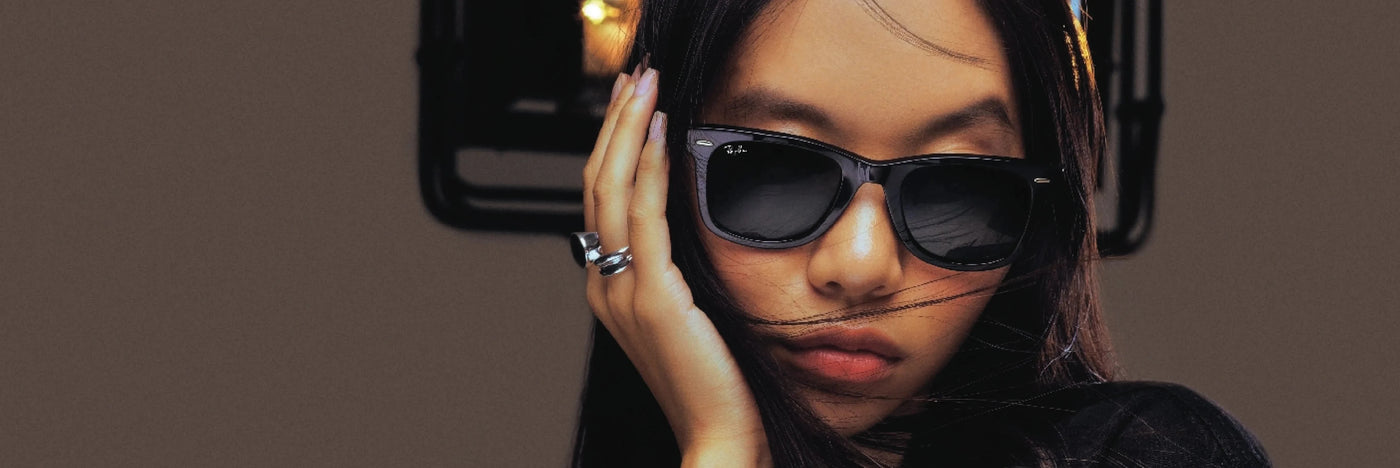 prety asian girl with black wayfarer sunglasses relaxing at home