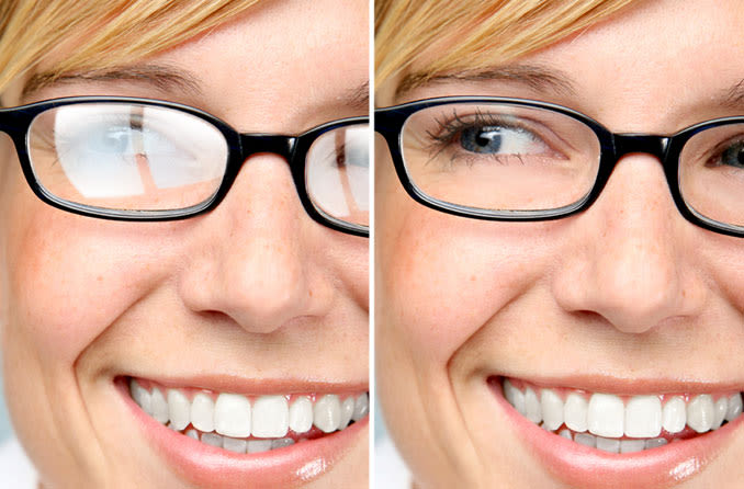 pretty lady with glasses demonstrating the difference betwwen eyeglasses treated with anti reflective coating and untreated lenses