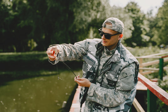 man fishing holds angling rod while wearing black sunglass on the river