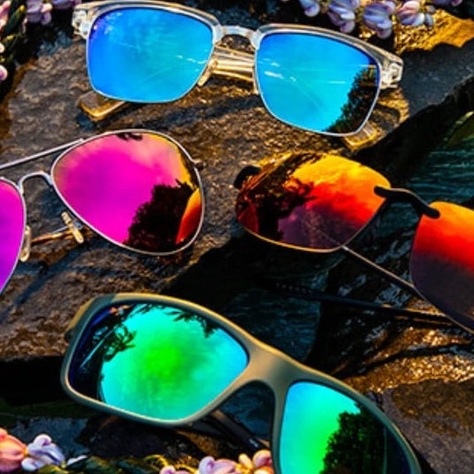 four fun mirrored colors for maui jim sunglasses - sunglasses laying on rocks demonstrating thier fantasic colors